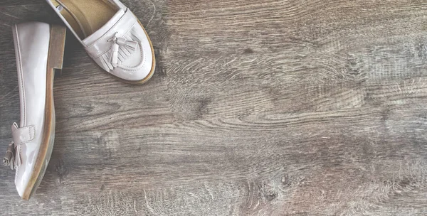 Mokasen ayakkabılar eski tarz tahta zeminde duruyor.