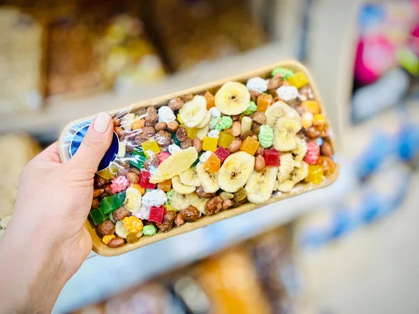 Süpermarketteki pakette farklı fındıklar ve kurutulmuş meyveler var. - Yakın çekim. Mobil fotoğraf