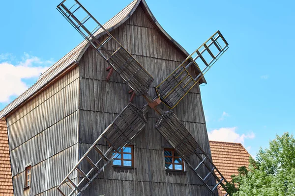 Foto av en gammal väderkvarn med träblad blå himmel. — Stockfoto