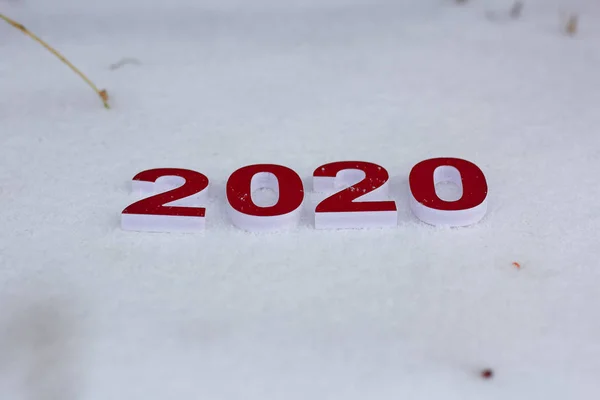 Números vermelhos estão na neve branca como um símbolo do próximo ano novo . — Fotografia de Stock