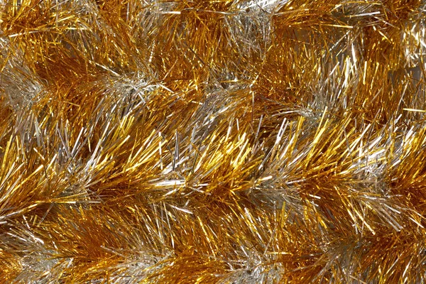 Glänsande guld tinsel foto närbild top view, jul bakgrund. — Stockfoto