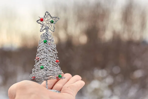 Spielzeug Weihnachtsbaum auf der Hand verschwommenen Hintergrund, auf das Thema des neuen Jahres. — Stockfoto