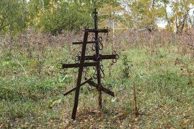 Two lonely crosses stand in the forest.