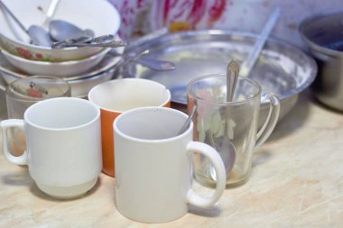 Masada kirli tabaklar, kupalar, tabaklar, kaşıklar. Mutfak, aşçı. Kir ve yemek artıkları..