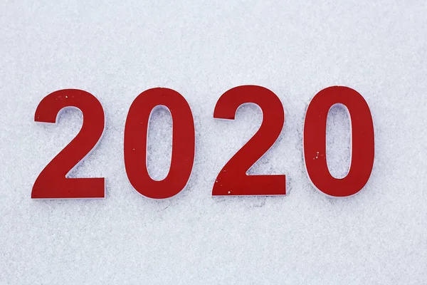 Os números vermelhos 2020 jazem na neve branca como um símbolo do próximo ano novo . — Fotografia de Stock