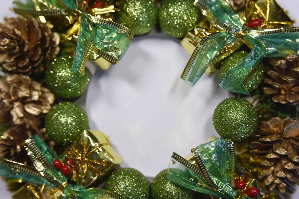 Conos de pino y formas brillantes verdes formando un garlan de Navidad — Foto de Stock