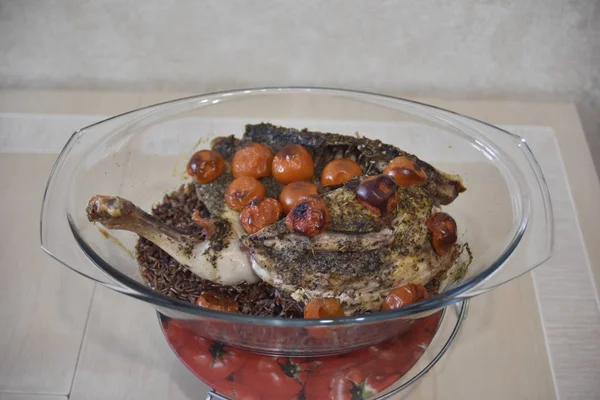 Запечённая курица с рисом басмати и овощами на стеклянной тарелке — стоковое фото