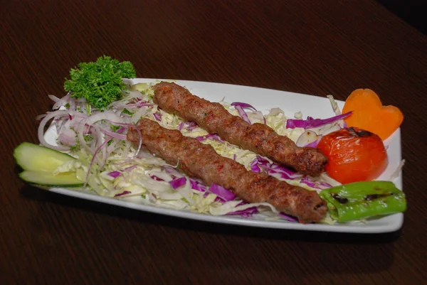Kebab alla griglia con insalata e verdure sul piatto bianco — Foto Stock