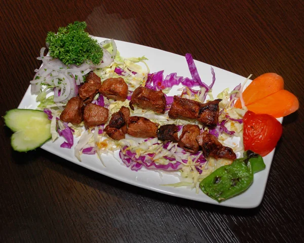 Carne de cordeiro grelhada com salada no prato branco — Fotografia de Stock