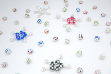 Farklı şekillerde gümüş boncuklar, mavi, yeşil kristaller...