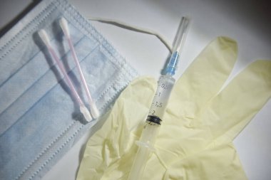 medical glove, syringe, mask and cotton buds on the white backgr