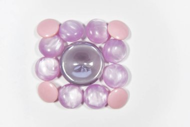 purple buttons of different shape and size on the white backgrou