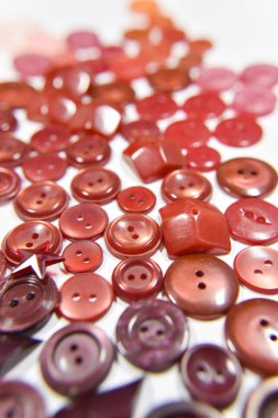 red buttons of different shape and size on the white background.