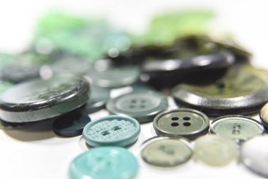 Green buttons of different shape and size on the white backgroun