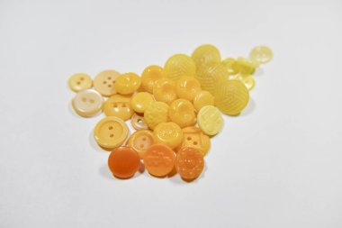 Yellow buttons of different shape and size on the white backgrou