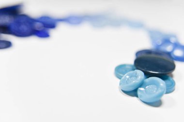 Blue buttons of different shape and size on the white background