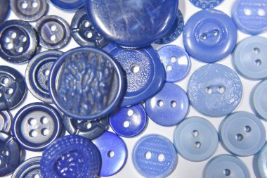 Blue buttons of different shape and size on the white background