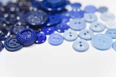 Blue buttons of different shape and size on the white background