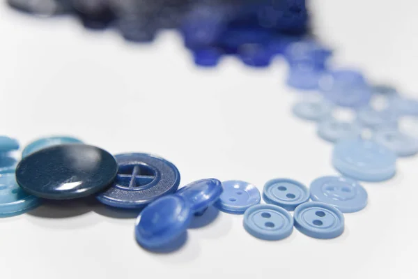 Blue buttons of different shape and size on the white background — 图库照片