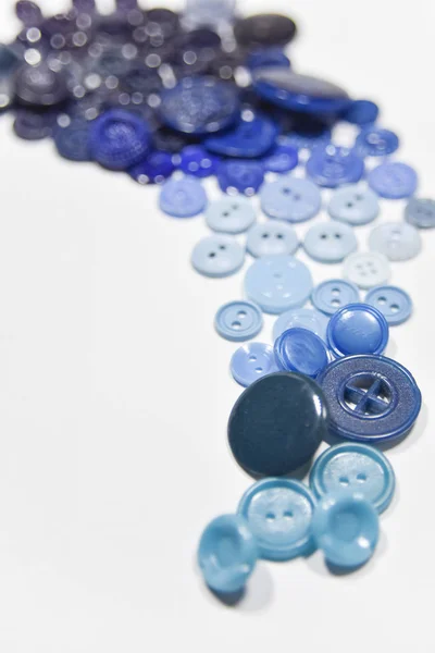 Blue buttons of different shape and size on the white background — 图库照片