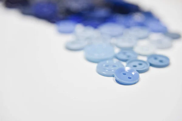 Blue buttons of different shape and size on the white background — 图库照片