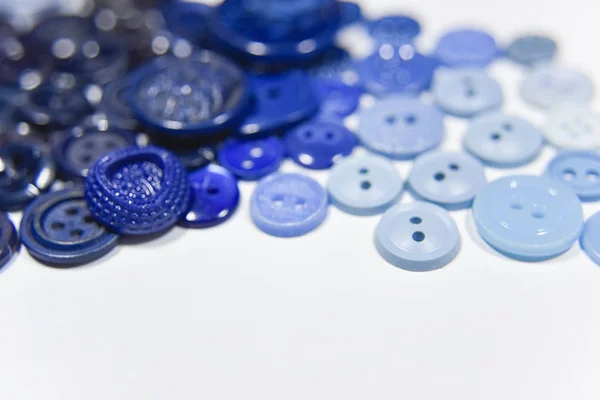 Botones azules de diferente forma y tamaño en el fondo blanco —  Fotos de Stock