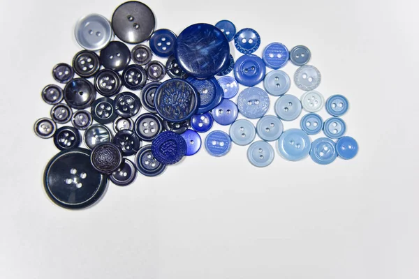 Blue buttons of different shape and size on the white background — 图库照片