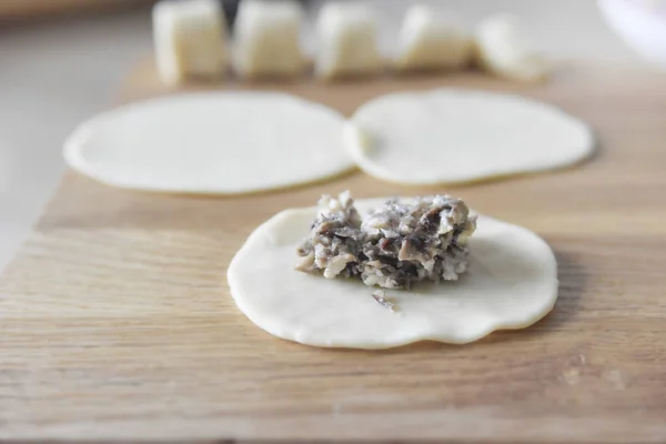 Kıymalı mantar ve hamurda tavuk. Hamur tatlısı yapma süreci. Doğal ışık. Yakından bak, seçici odaklanma.