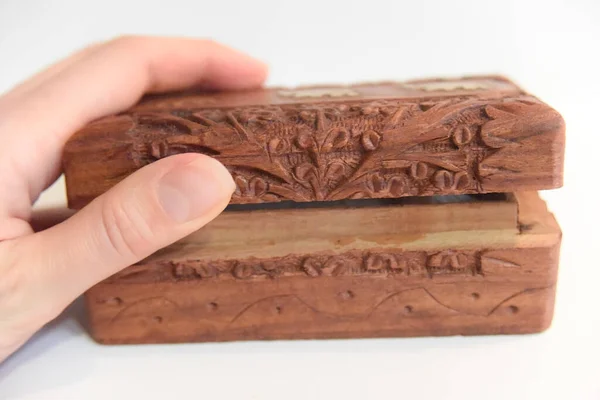 Kadın eli oyulmuş tahta kutuyu açıyor.