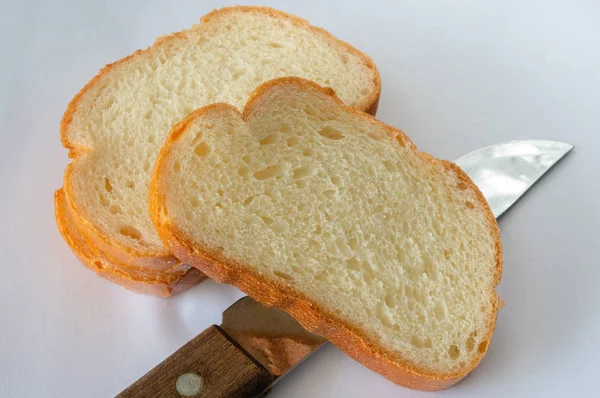 Χρυσό ψωμί κομμένο σε φέτες με μαχαίρι — Φωτογραφία Αρχείου