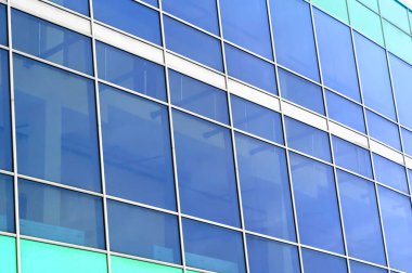 Binanın camları parlıyor. Cam uçak arka planı. Binanın ön cephesinde mavi camlar.