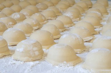 Çiğ hamur köftelerinin arka planı çapraz olarak un tabakasının üzerine uzanır.