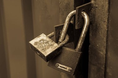 Demir kapıya eski demir kilitler takılmış. Terk edilmiş kapalı kapılar