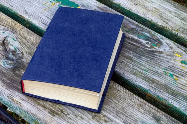 Een Blauw Boek Ligt Armoedige Oude Planken Een Bankje — Stockfoto