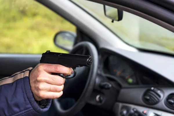 Hombre con un arma conduciendo un coche, mano masculina con un arma — Foto de Stock
