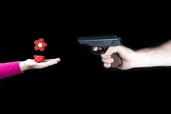 Männliche Hand mit Waffe gegen Kinderhand mit roter Blume, Waffe stoppen, Krieg beenden — Stockfoto