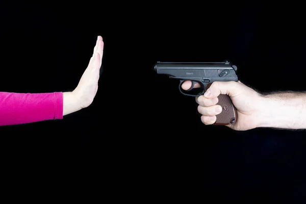 Männliche Hand mit einer Waffe gegen die Hand eines Kindes, stoppt eine Waffe, stoppt einen Krieg — Stockfoto