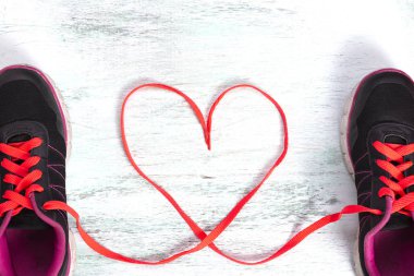 bir çift ayakkabı bağcıklarımı ahşap zemin üzerinde kalp şekil verme ile en iyi görünümü. şeker kalp yapılan