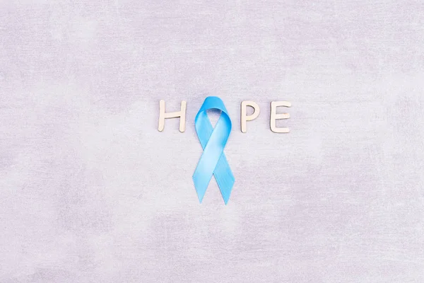 保健和医学概念-蓝色前列腺癌意识带和单词希望，由木制字母，亚洲和肾上腺皮质癌，灰色背景，平躺，顶部视图，平躺，顶部制成 — 图库照片