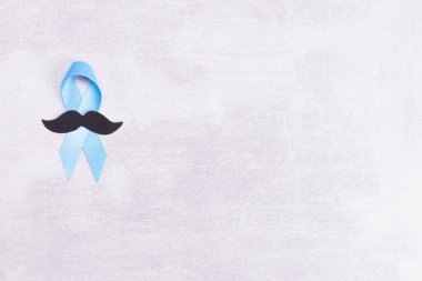 Sağlık ve İlaç Konsepti - mavi prostat kanseri farkındalığı kurdelesi ve kağıt siyah bıyık, akhalasya ve adrenokortikal kanser, gri arka plan, düz alan, üst görünüm, metin için yer