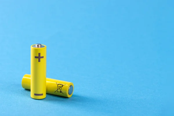 Dos baterías amarillas sobre fondo azul con lugar para texto — Foto de Stock