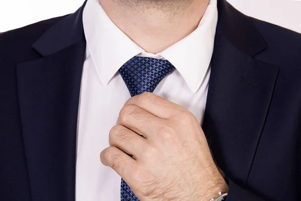 Бізнесмен в темному костюмі фіксує краватку — стокове фото