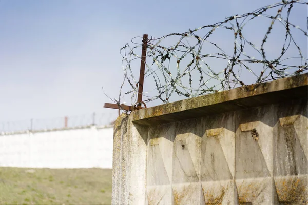 Barbed wire fence against the blue sky.