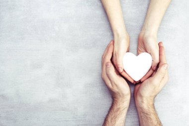 Beyaz kalpli erkek ve kadın elleri, sağlık, aşk ve aile sigortası konsepti, dünya kalp günü, dünya sağlık günü, koruyucu aile, uluslararası aile günü.