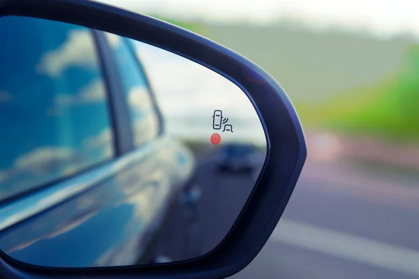Spot cego Sistema de monitoramento ícone de luz de advertência no espelho de visão lateral de um veículo moderno — Fotografia de Stock