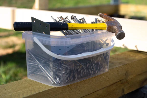 Nails and hammer in the construction of a wooden house — Stock Photo, Image