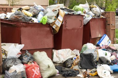 Minsk, Belarus, 3 Mayıs 2020. Şehir sokaklarındaki çöp toplama sorunları - bir apartman bloğunun sakinlerinden gelen çöp konteynırları ve onların yanındaki çöpler.