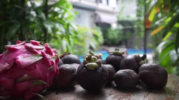 Frutas jazem em uma mesa na piscina de fundo dragão fruta, mangostão — Vídeo de Stock