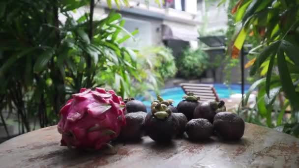 Fruits lie on a table in the background pool dragon fruit, mangosteen — Stock Video