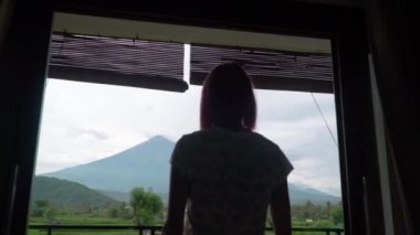 Kız, Bali adasındaki Agung volkanı perdelerini açıyor.